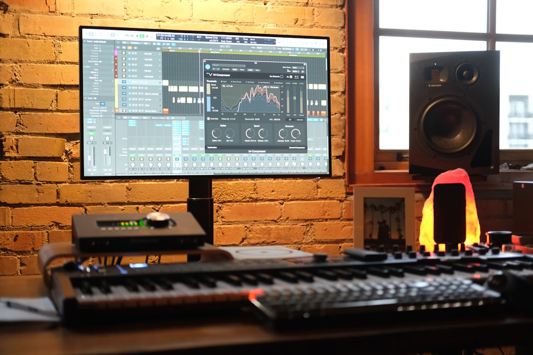 a computer monitor sitting on top of a wooden desk music production software interface, digital audio workstation screen, electronic music setup