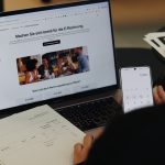 A man sitting in front of a laptop computer entrepreneur working on laptop, branding board, logo sketches, small business workspace
