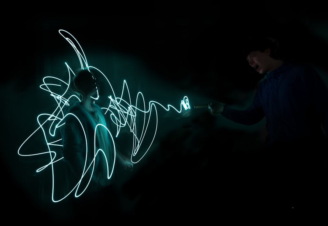 a man standing in the dark holding a light painting dragon pokemon using powerful attack, glowing blue energy, battle arena minecraft