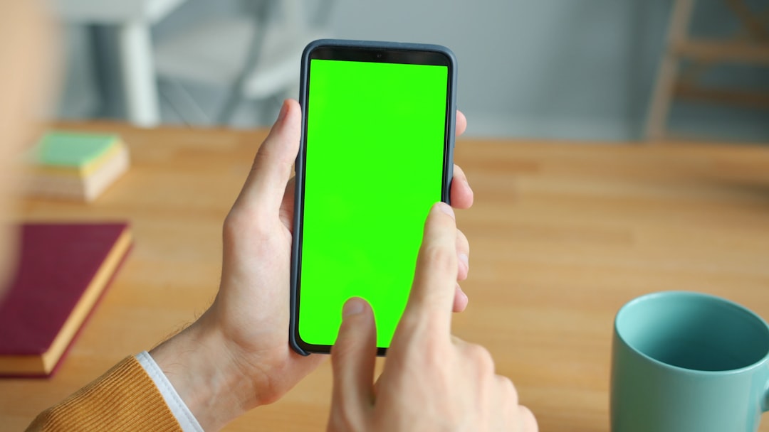 Person holding a smartphone with a green screen. comparison chat apps on smartphone screens, whatsapp and telegram interface, messaging icons