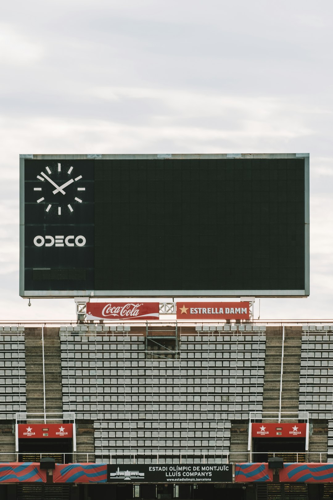 a large scoreboard on the side of a stadium billboard with qr code, outdoor advertising, person scanning with smartphone