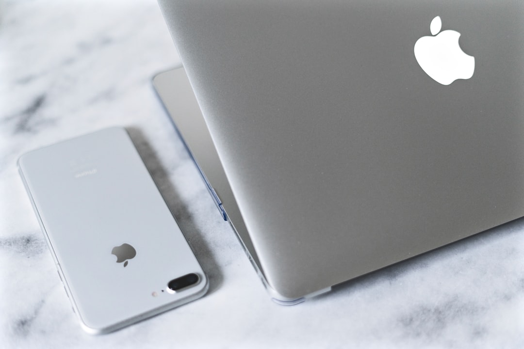 silver iphone 6 on white table iphone connected to laptop, itunes backup screen, mac finder restore iphone