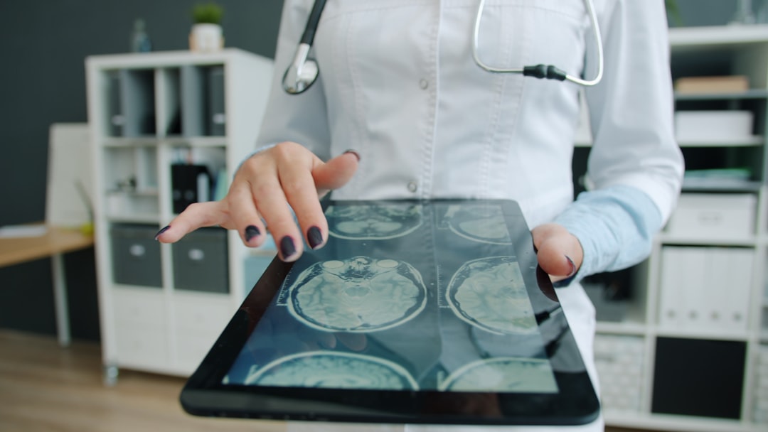 Doctor shows brain scan on tablet in office doctor using tablet, hospital data dashboard, artificial intelligence healthcare