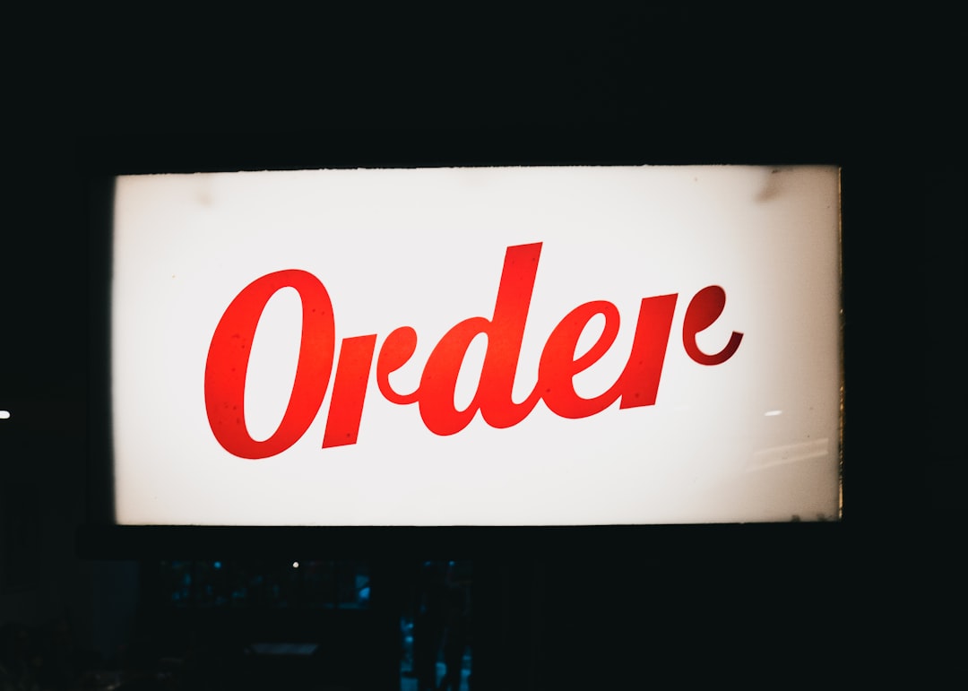 a red order sign hanging from the side of a building order matching, payment transaction, tracking number