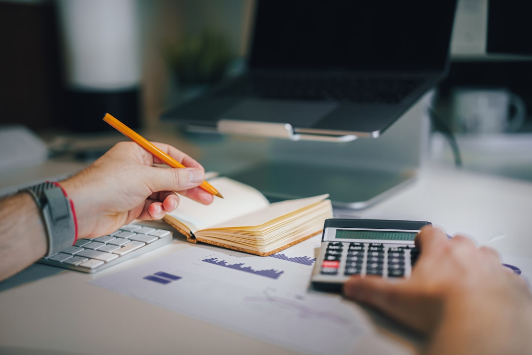 a person sitting at a desk with a calculator and a notebook financial planning desk, calculator notebook, savings growth chart