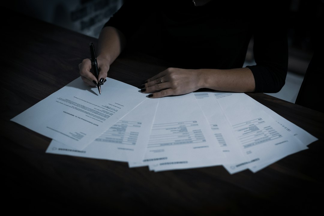 a woman sitting at a table with lots of papers sole proprietor, limited liability company, business paperwork