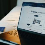 Laptop, phone, and card on a bed. online shopping, credit card charges, laptop subscription page