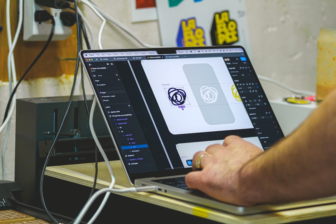 Person designing on a laptop computer screen. emblem design, vector badge, creative workspace