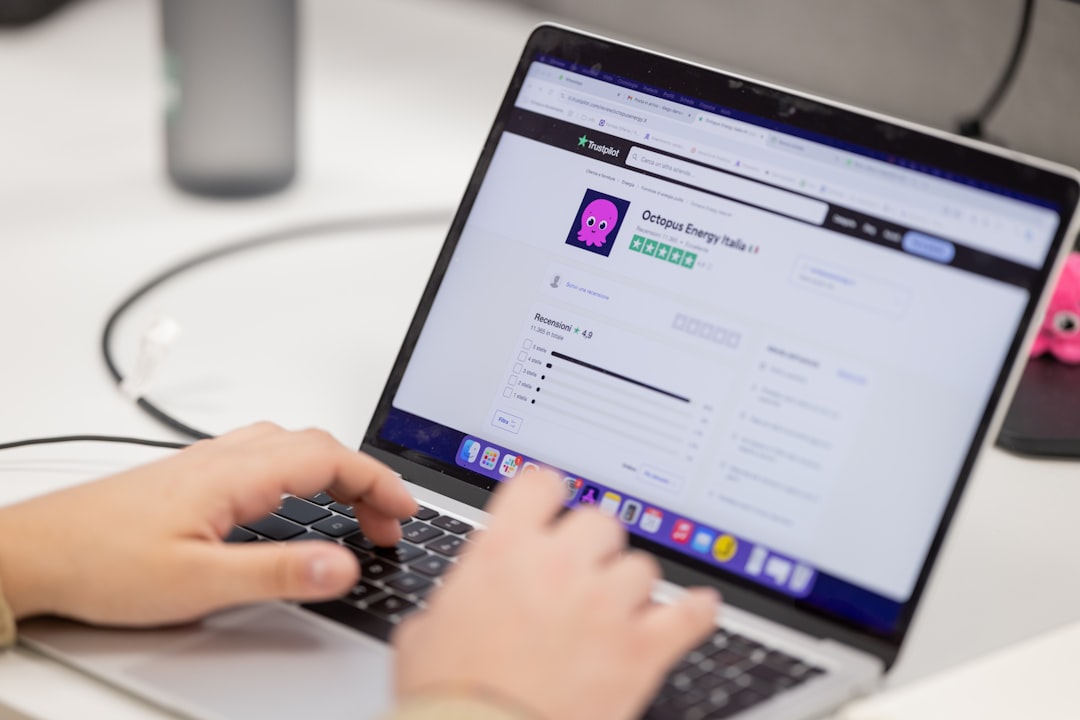 Person typing on a laptop computer screen. digital asset dashboard, brand management interface, content library screen