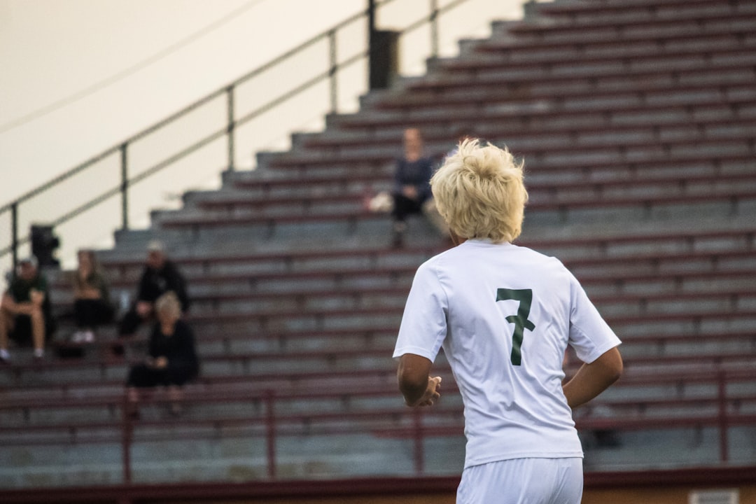 Soccer player with number seven on jersey runs on field soccer team, jerseys, stadium, team spirit