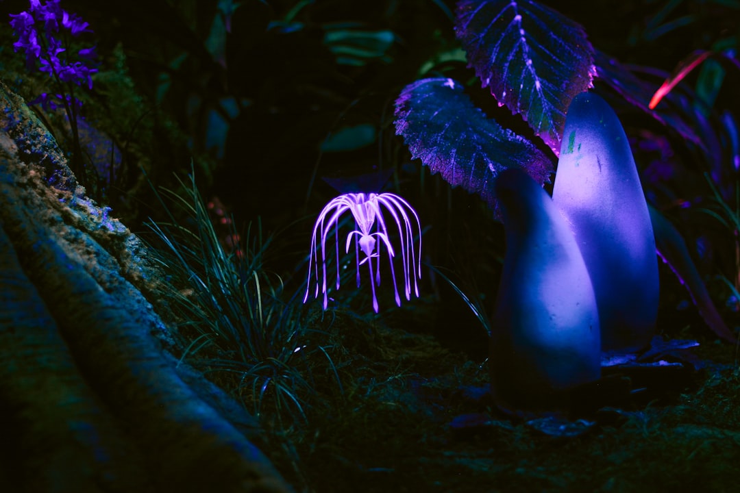 purple flower near grass glowing pollen, fantasy mouth, plant creature