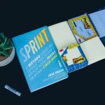 Sprint book and black marker business card template on screen, modern office desk, graphic design interface