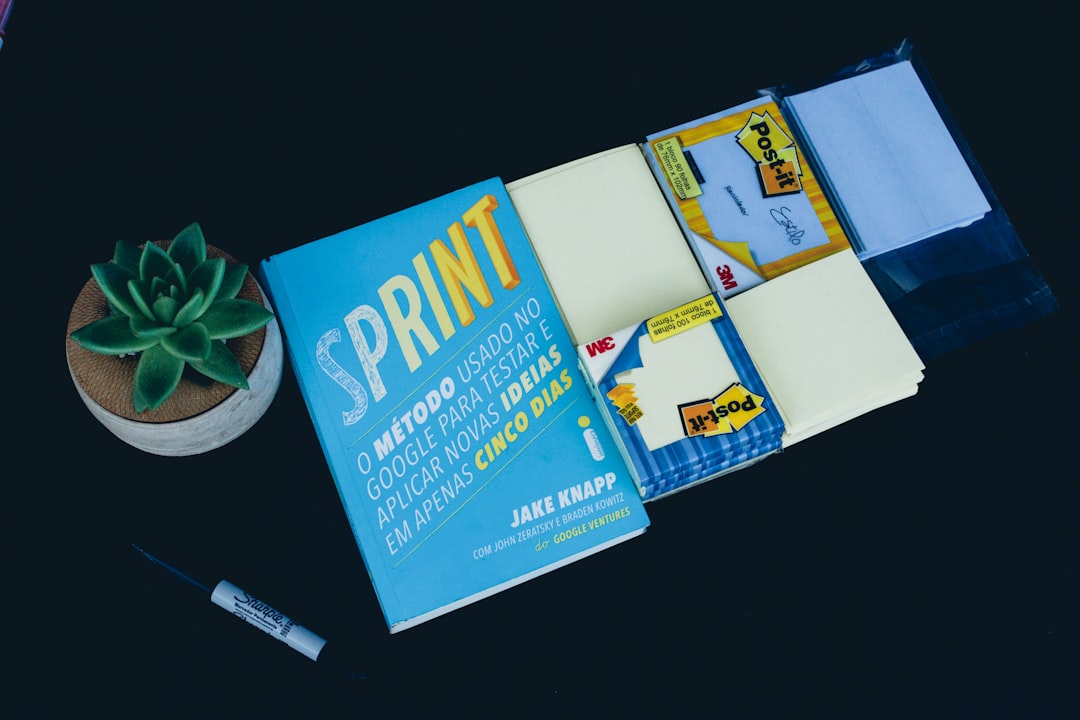 Sprint book and black marker business card template on screen, modern office desk, graphic design interface