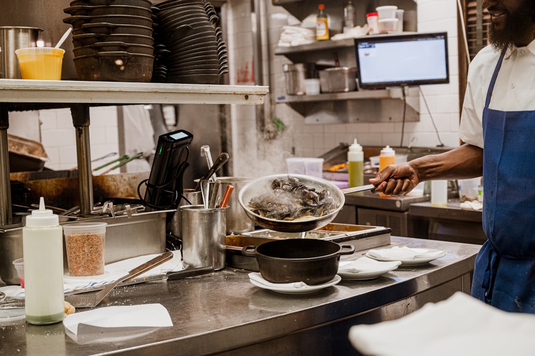 a man standing in a kitchen preparing food kitchen display, restaurant orders, chefs, indian food