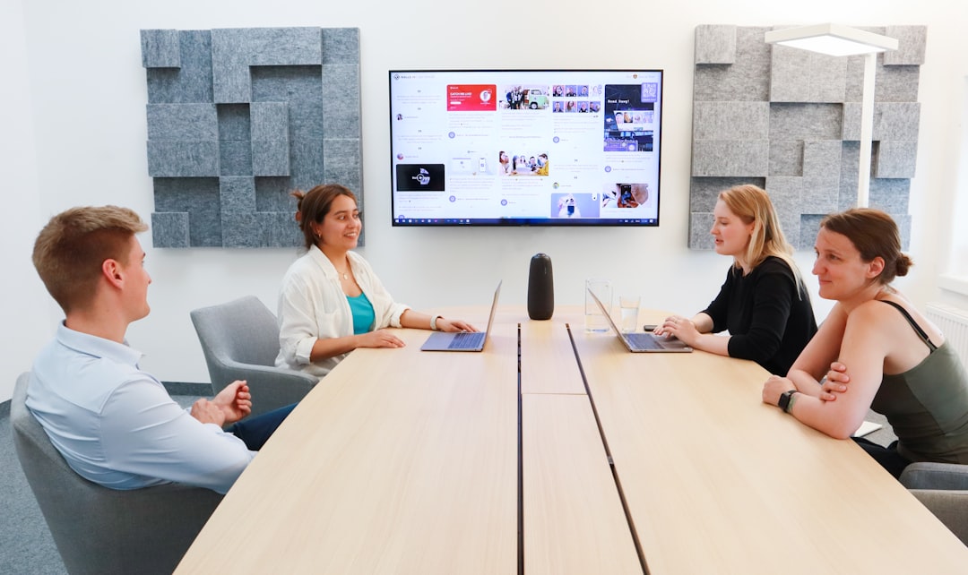 a group of people sitting around a conference table business communication platform, team video meeting, shared documents screen, office collaboration