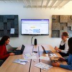 a group of people sitting around a conference table project management dashboard, creative team collaboration, task approval workflow