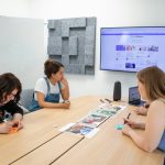 a group of people sitting around a wooden table project management dashboard, creative team collaboration, task approval workflow