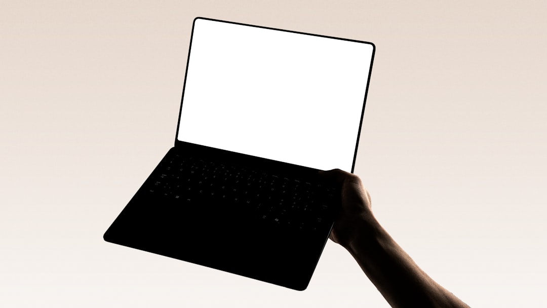 A hand is holding a laptop. developer workspace modern laptop dark mode code editor