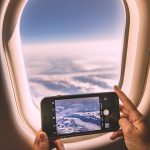 a person holding a phone smartphone flight booking app, price prediction chart, travel planning screen