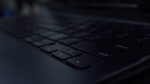 Close-up of a dark computer keyboard developer workspace modern laptop dark mode code editor