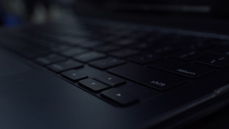 Close-up of a dark computer keyboard developer workspace modern laptop dark mode code editor