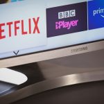 white and black digital device samsung smart tv home screen, netflix app icon, tv remote control