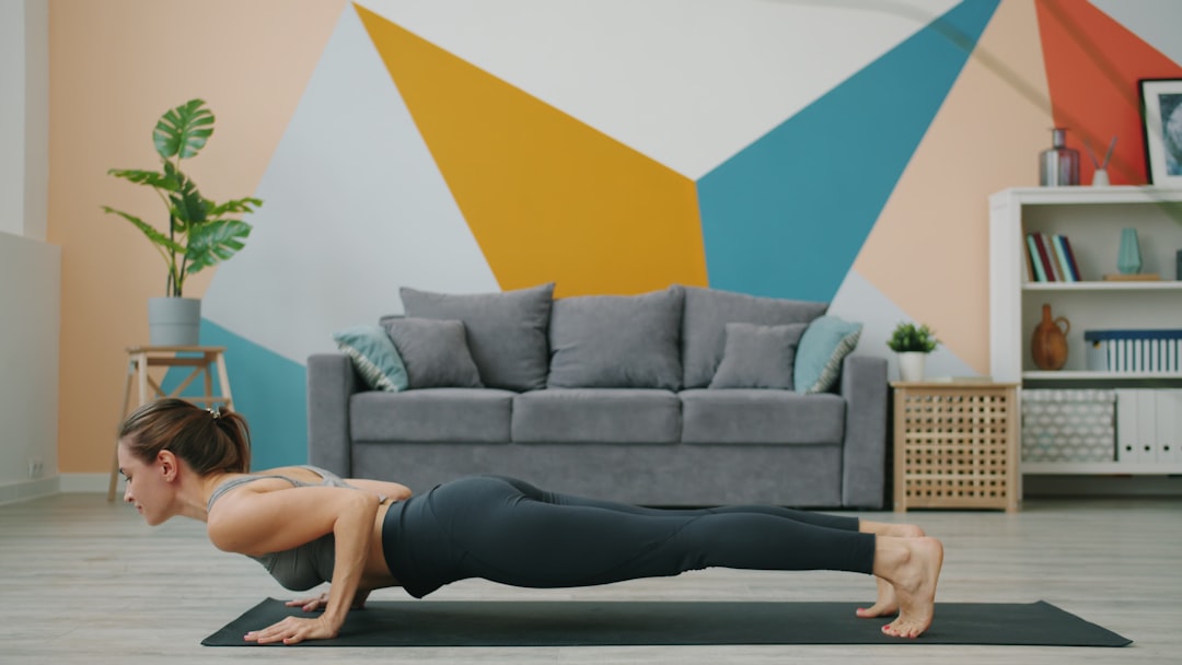 Woman doing a push-up on a yoga mat indoors. person stretching yoga mat calm room recovery