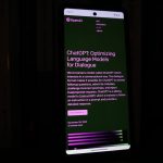 a cell phone with a lit up screen in the dark twitch chat interface, emote spam chat, streaming platform screen