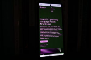 a cell phone with a lit up screen in the dark twitch chat interface, emote spam chat, streaming platform screen