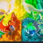 A couple of figurines sitting on top of a table dragon pokemon using powerful attack, glowing blue energy, battle arena minecraft