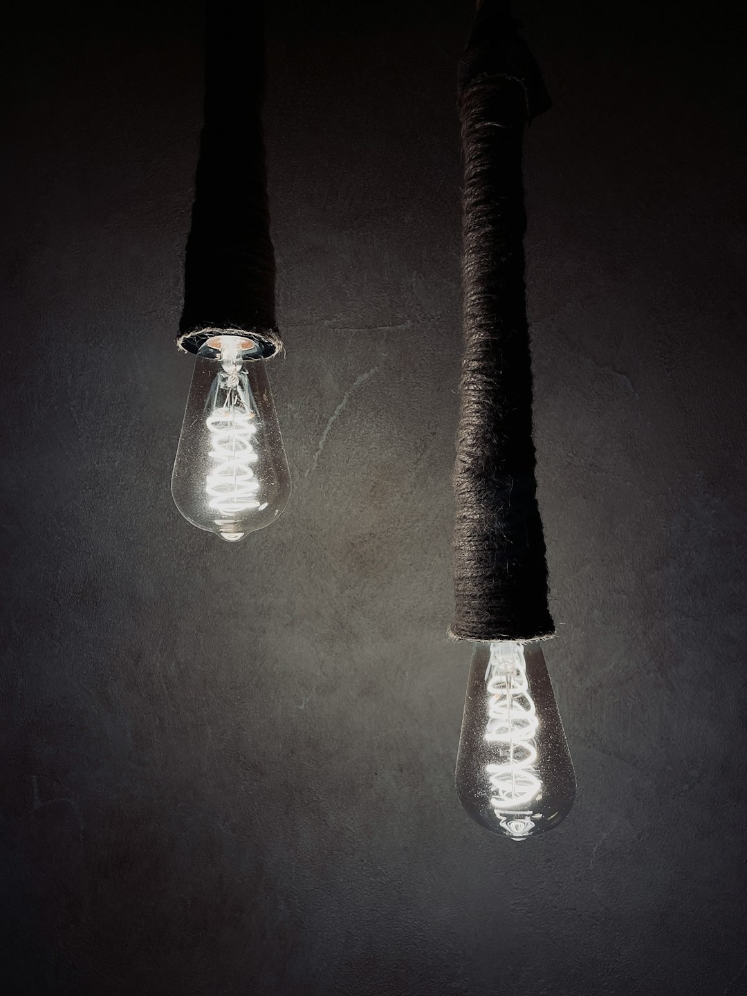 a couple of light bulbs hanging from a ceiling lightbulb idea concept, simple analogy illustration, comparison visual