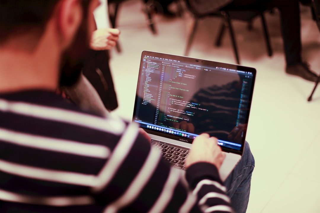 a man sitting in front of a laptop computer developer coding laptop authentication system interface