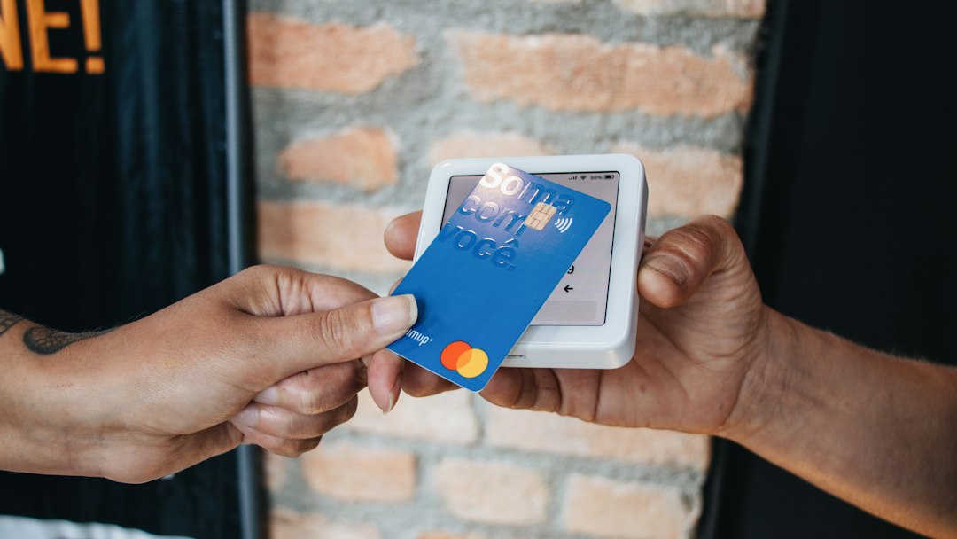 a person handing a credit card to another person mobile card reader, small business payment, fintech innovation office
