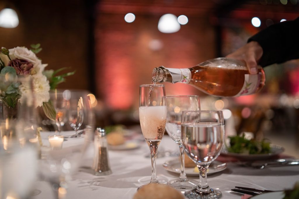 a person pouring wine into a glass on a table prosecco with appetizers, italian antipasto platter, sparkling wine brunch table