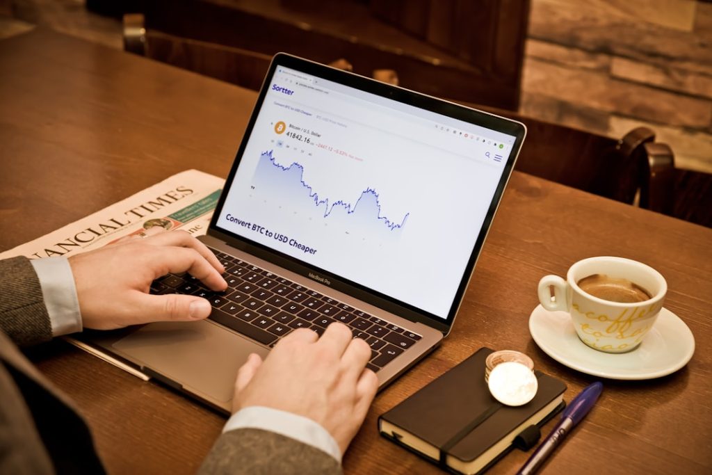 a person using a laptop on a wooden table small business owner laptop dashboard accounting software