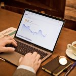 a person using a laptop on a wooden table small business owner laptop dashboard accounting software