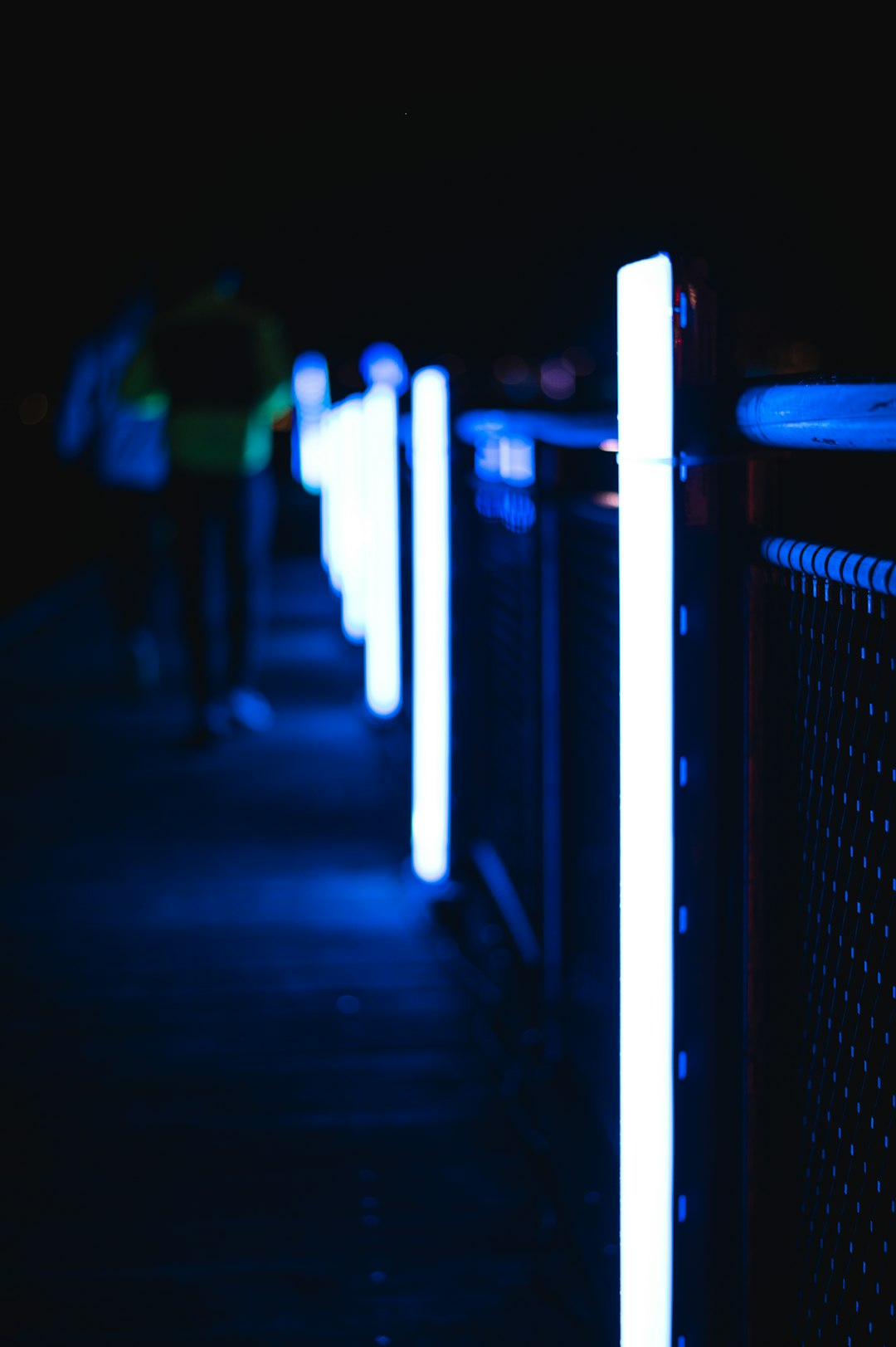 a person walking down a sidewalk at night cloud server data center racks glowing lights