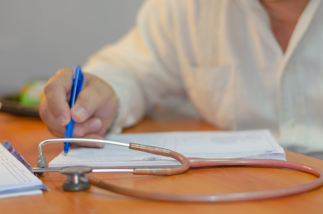 a person writing on a piece of paper with a stethoscope hospital compliance meeting, accreditation audit paperwork, medical staff reviewing documents