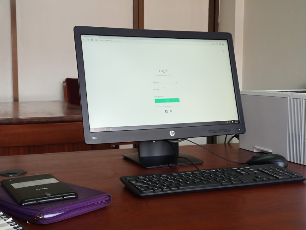 black computer monitor turned on beside black computer keyboard healthcare compliance dashboard, hipaa report screen, office computer setup