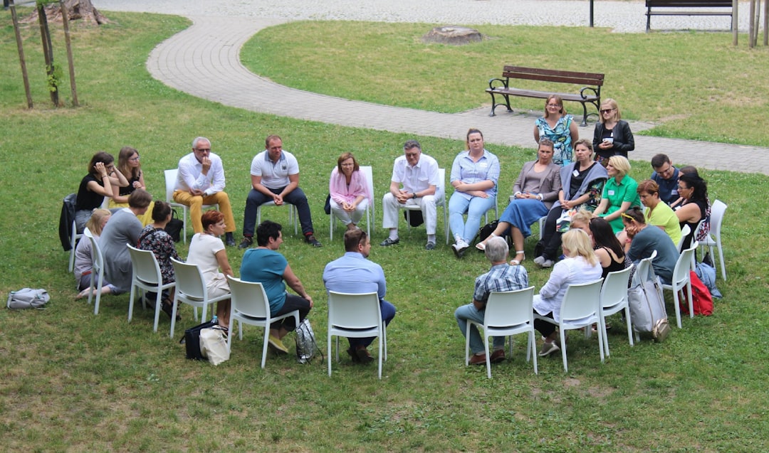 circle of people sitting on chair on grass fiedl community networking event, professionals networking, digital community meetup