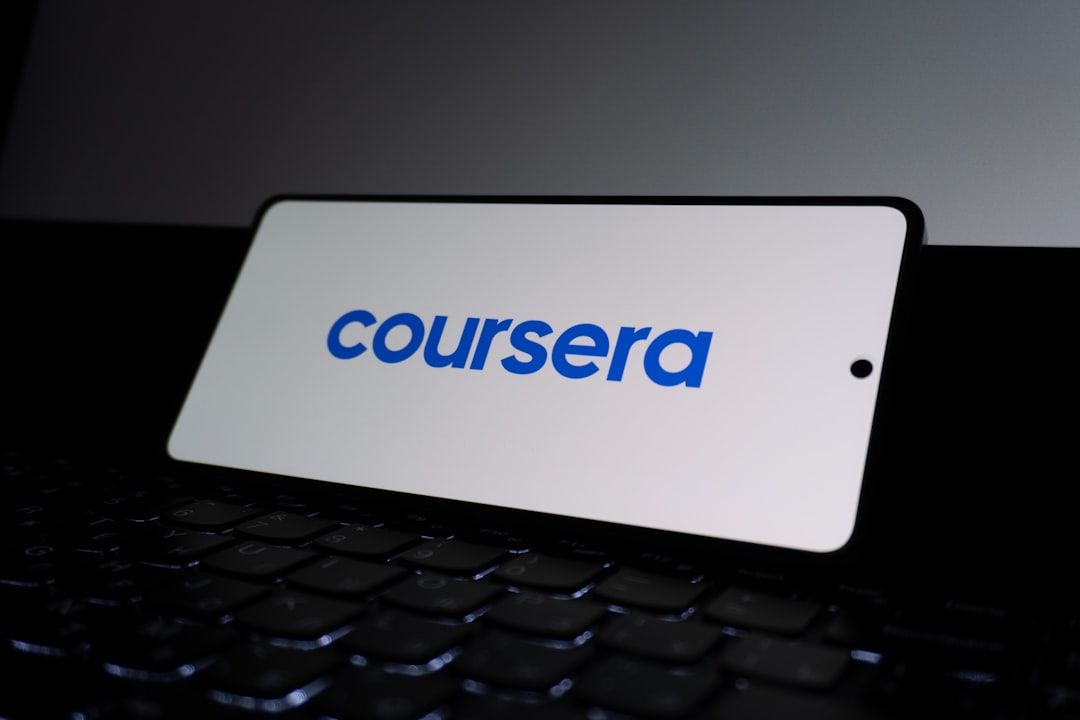 Coursera logo on a smartphone screen. corporate training dashboard, online learning interface, employee course platform