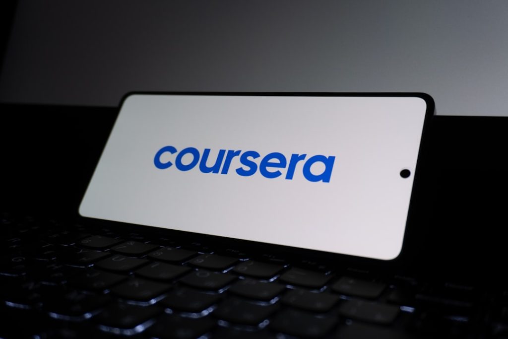 Coursera logo on a smartphone screen. corporate training dashboard, online learning interface, employee course platform