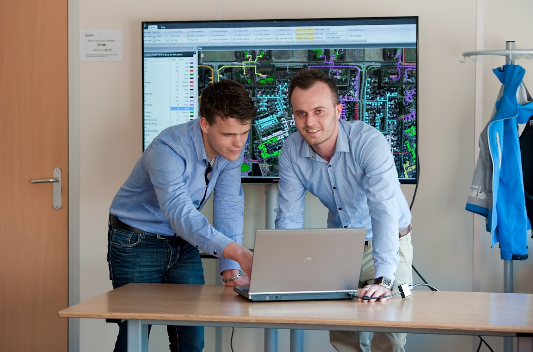 man in blue dress shirt using macbook pro real estate team meeting, digital analytics screen, sales performance charts
