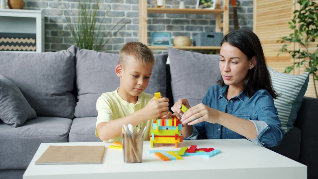 Mother and son building with colorful blocks person teaching child, simple explanation concept, learning at home