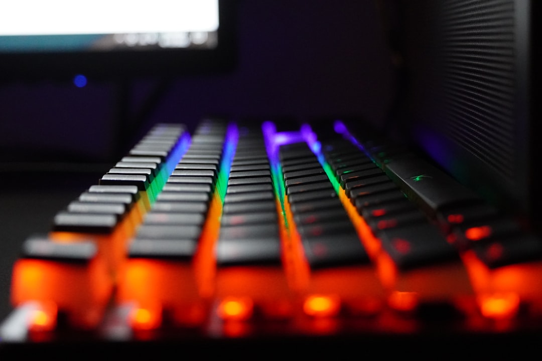 a close up of a keyboard with a monitor in the background mechanical keyboard, colorful keycaps, desk setup, rgb lighting