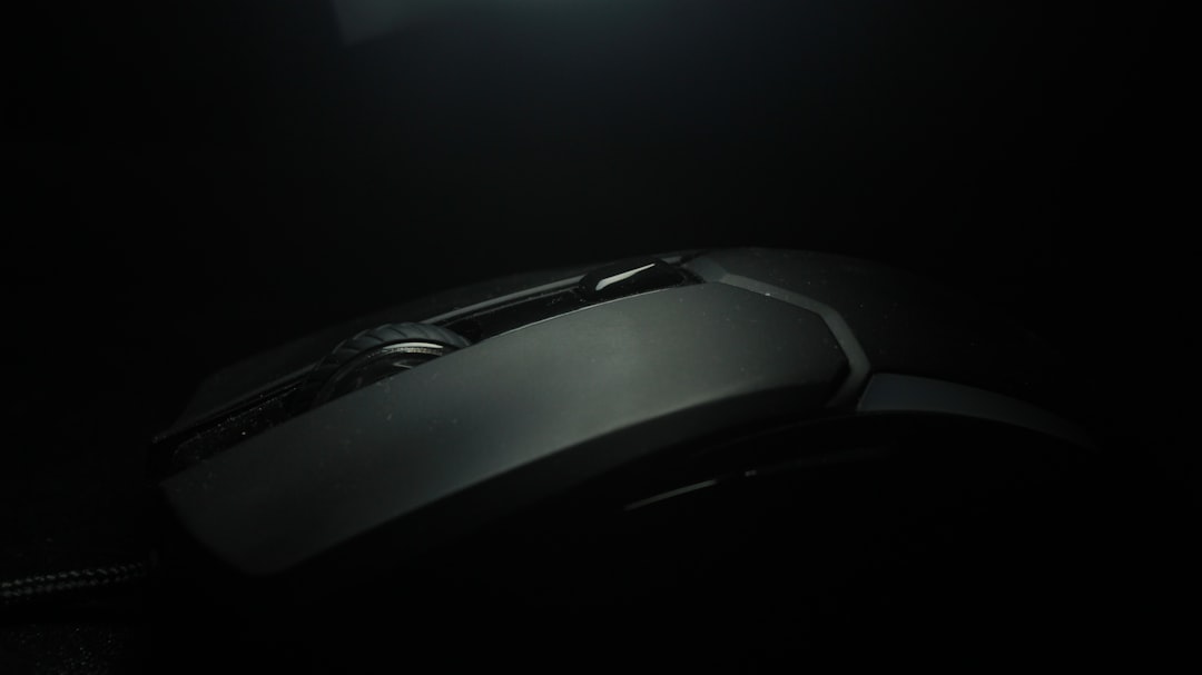 a computer mouse sitting on top of a desk gaming mouse close up, scroll wheel detail, hand using gaming mouse