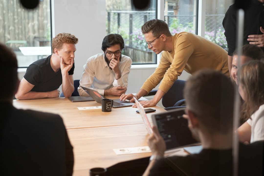 a group of people sitting around a wooden table team dashboard, meeting analytics, task tracking