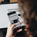 A person holding a cell phone in front of a laptop newsletter design, mobile email, ecommerce sales, automation flow