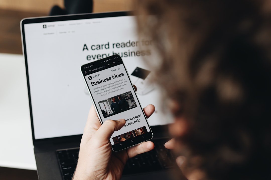 A person holding a cell phone in front of a laptop newsletter design, mobile email, ecommerce sales, automation flow