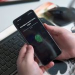 a person holding a phone person using tor browser on smartphone, privacy shield icon, secure browsing app interface, modern mobile screen
